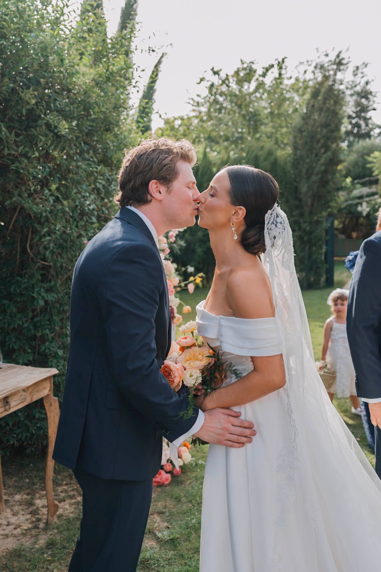 Romantic wedding moment captured in a lush garden setting during golden hour.