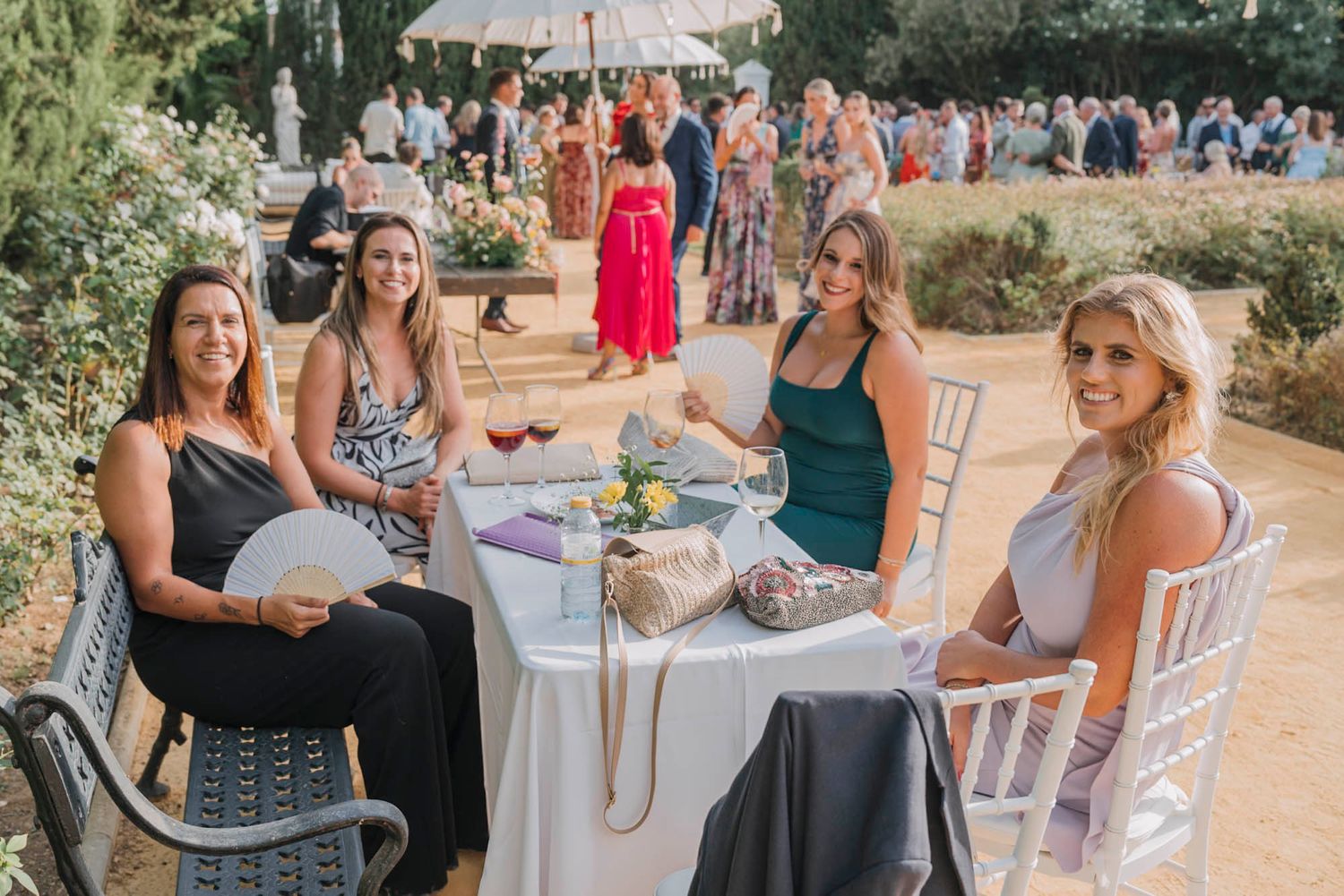 Wedding guests enjoying refreshments at an outdoor table setting.