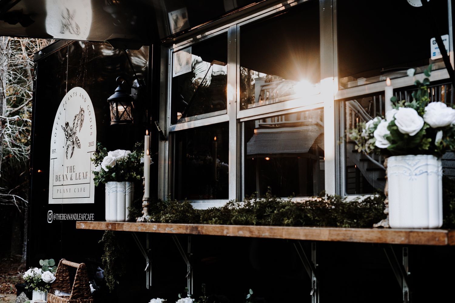 Window display of The Bean & Leaf cafe with sunburst lighting and decorative elements.