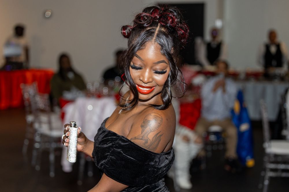 A joyful party scene with someone dancing in a black off-shoulder dress at an event.