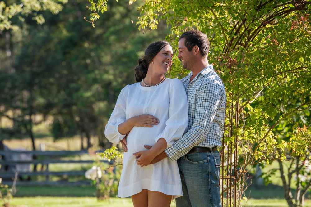 Couple shares tender moment in sunlit garden setting.