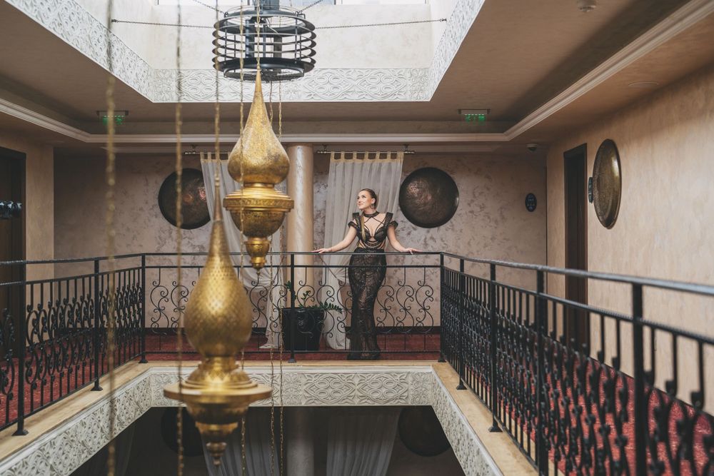 Interior architecture shot featuring golden hanging lamps and decorative railings in atrium space.