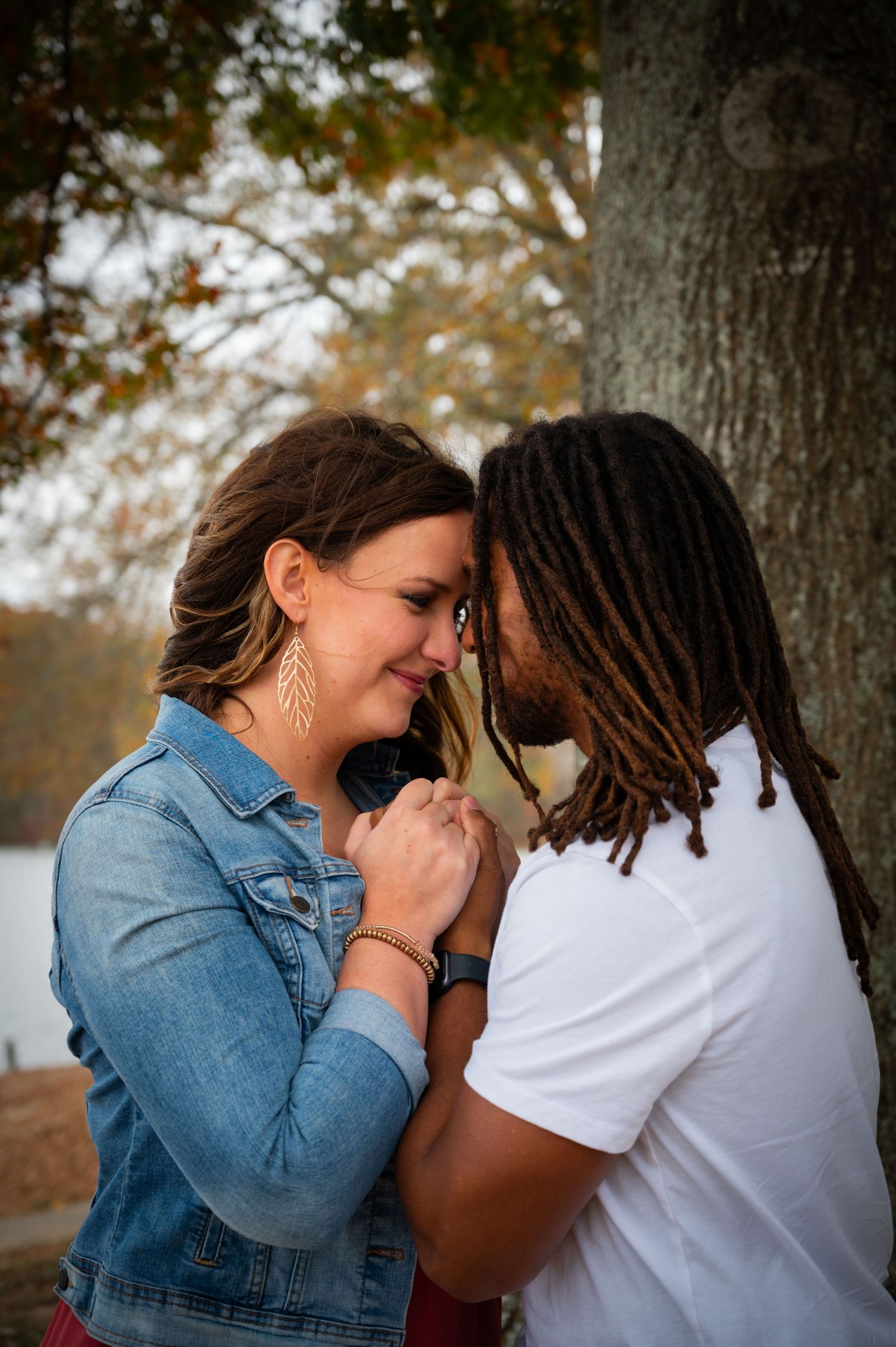 Intimate outdoor photo session showing tender moments between a couple against a tree backdrop.