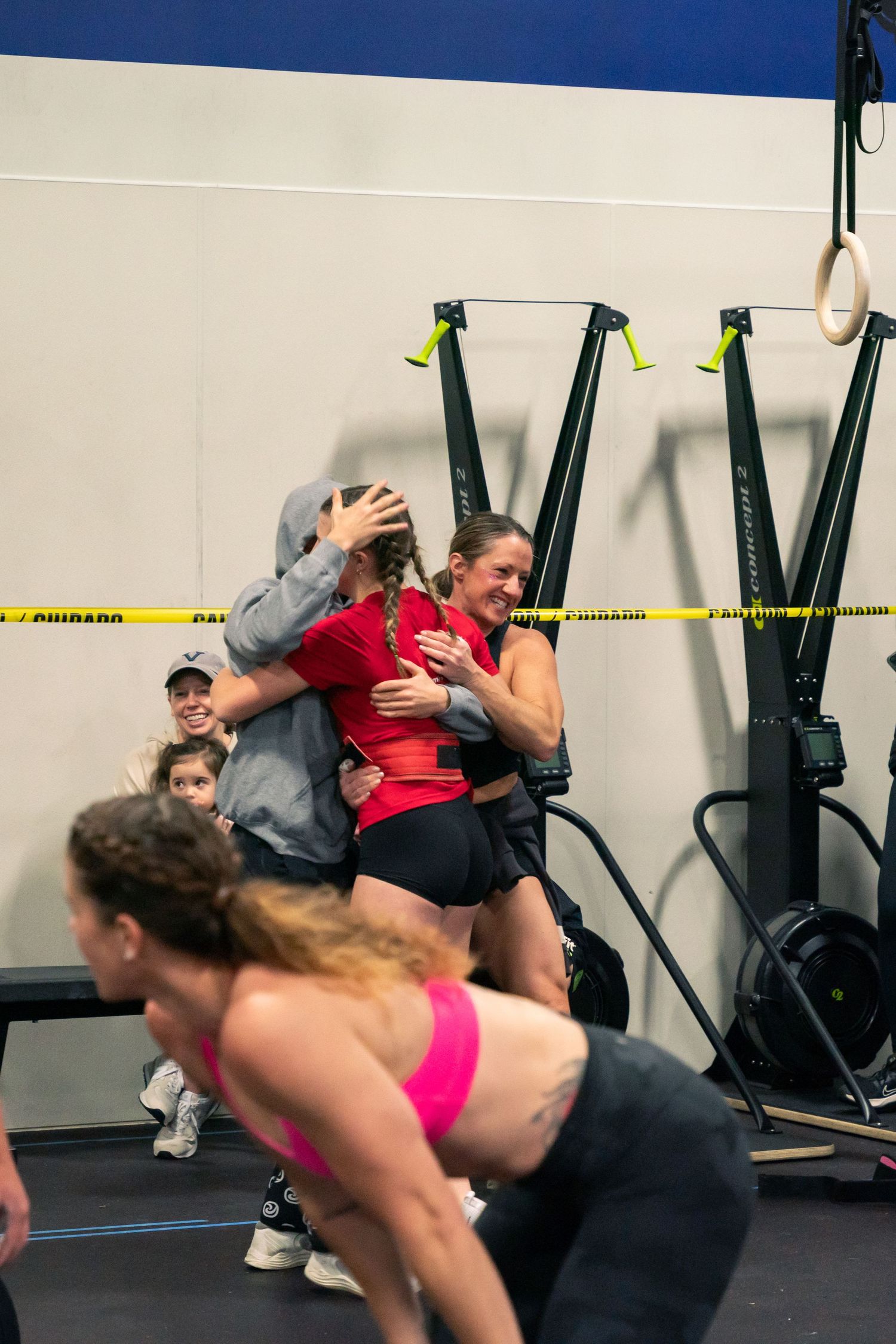 Athletes engaged in dynamic CrossFit workout with medicine balls and exercise equipment.
