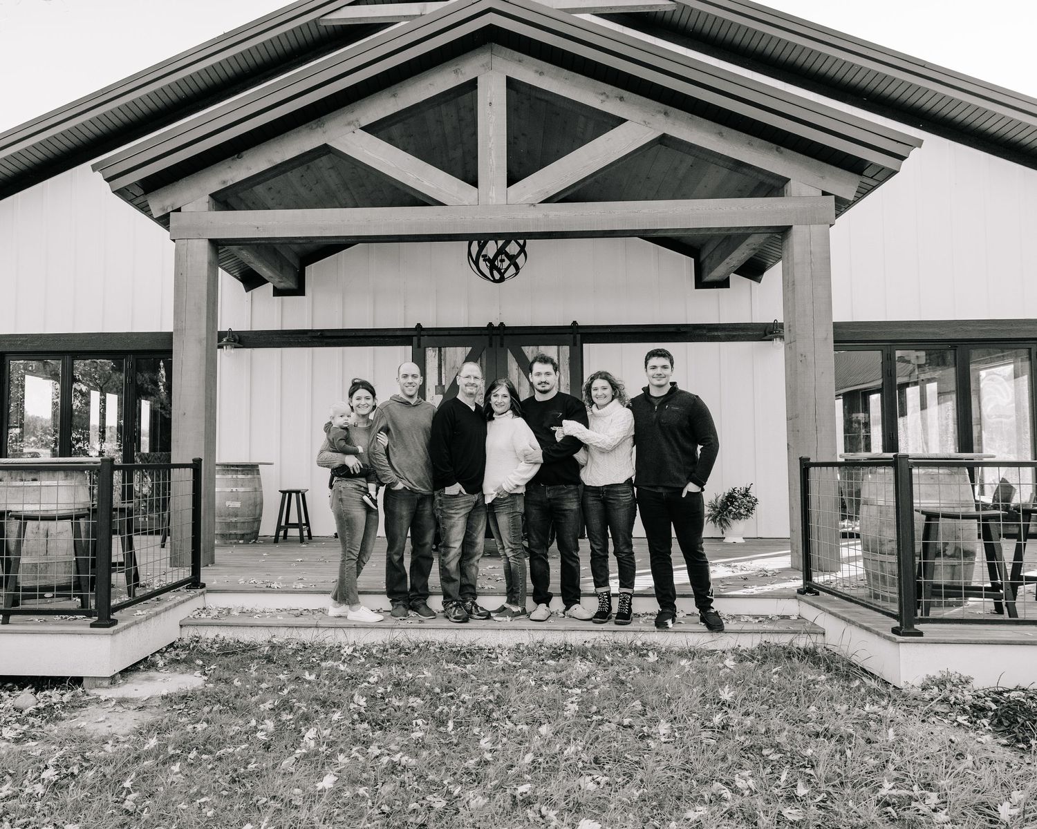 Group photo of people standing on porch of rustic building entrance.