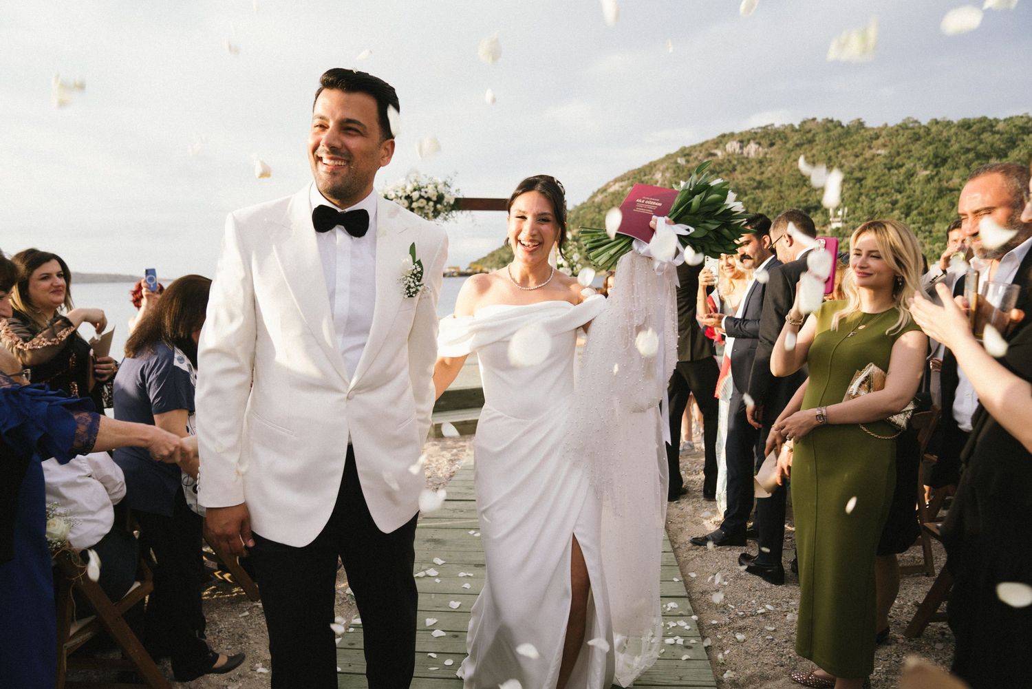 Wedding party celebration with guests in formal attire outdoors.