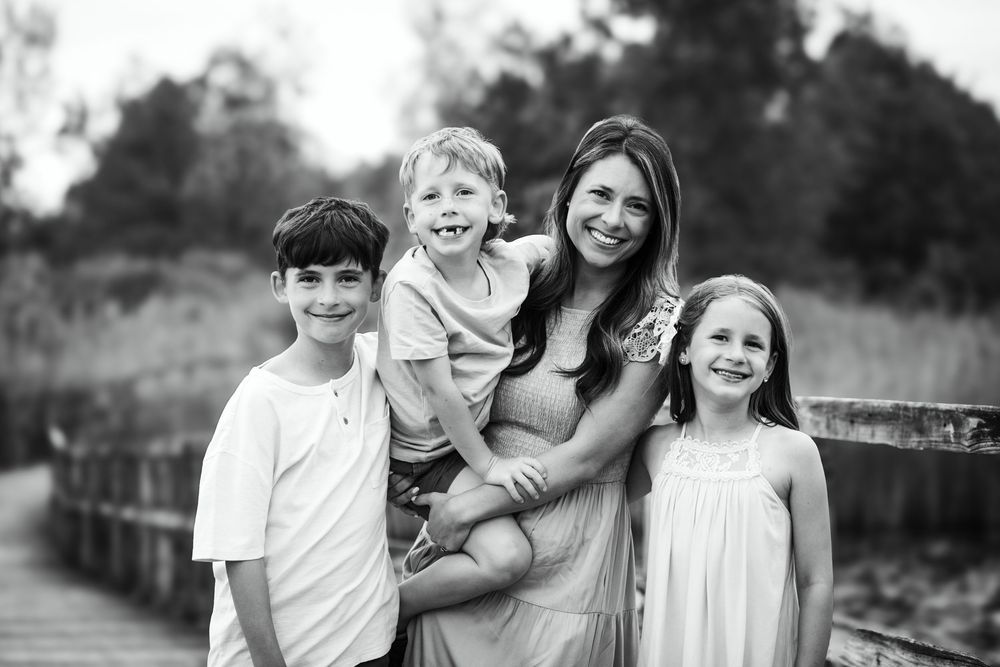 Black and white candid photo of a family group laughing together outdoors.