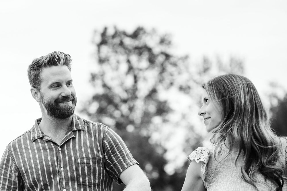 Black and white portrait of a couple sharing a loving glance outdoors.