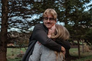 A joyful embrace captured during a special moment in a forest setting.