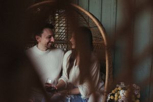 Couple sharing an intimate moment in a rattan hanging chair.