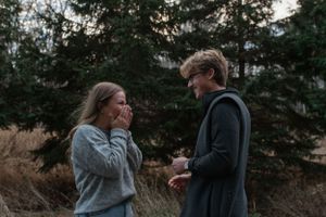 An emotional exchange between two people during a special moment in a forest setting.