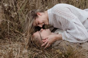 Intimate portrait of couple sharing close moment in autumn field.