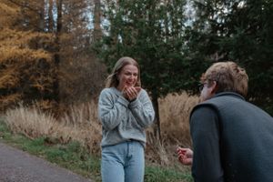 A heartfelt reaction to a surprise proposal amongst autumn trees and foliage.