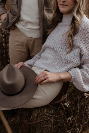 Close-up detail of cozy winter outfits with a brown felt hat and knit sweater.
