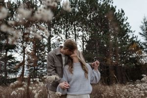 A tender moment captured between a couple in a rustic outdoor setting.