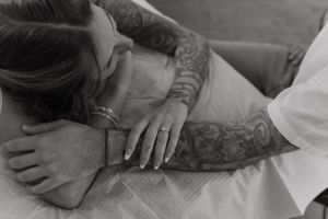 Black and white photo showing detailed tattoo work on person's arm.