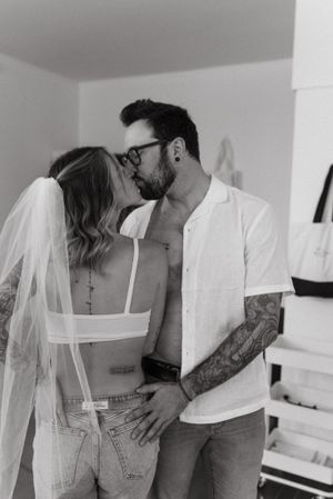 Intimate black and white portrait of couple sharing a moment in white room.