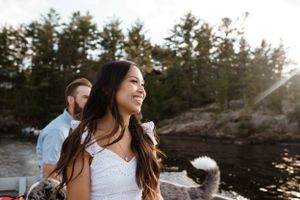 A waterfront scene with a couple enjoying a sunny day by the rocky shore.