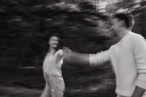 Motion-blurred black and white photo of couple dancing in nature.