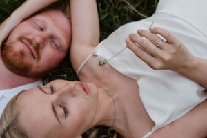 Intimate couple relaxing together in a grassy meadow.