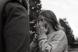 A black and white photograph capturing an emotional reaction during a special moment outdoors.