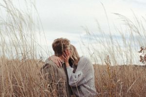 A tender embrace captured between two people in a wheat field.