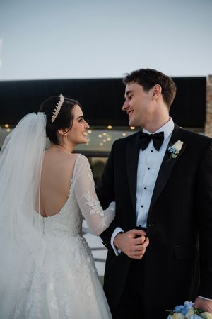 A romantic wedding portrait series showing tender moments between newlyweds against a soft evening backdrop.