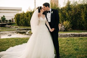 A wedding couple shares intimate moments in an outdoor garden setting with natural greenery.