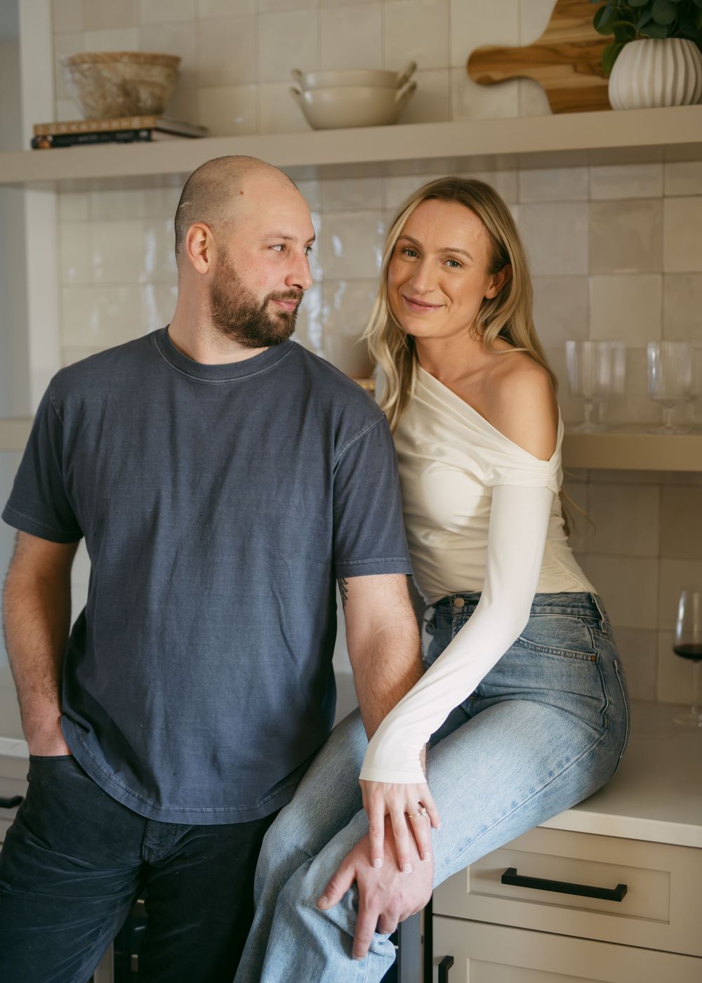 Intimate kitchen scene with couple in casual clothing sharing a moment.