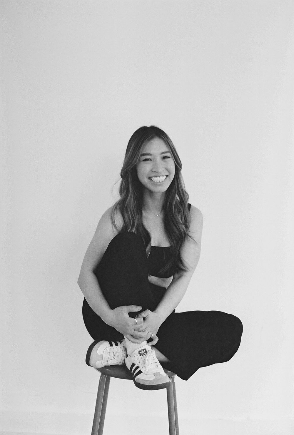 Black and white portrait series showing dynamic seated poses on a stool.