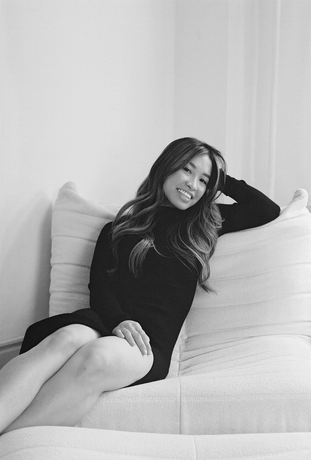 Artistic black and white photos capturing relaxed moments on a white couch.