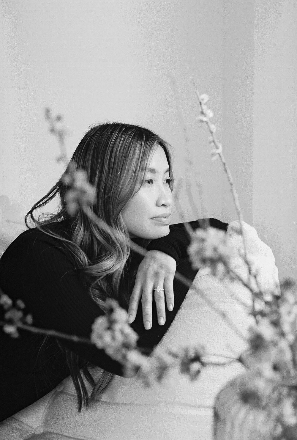 Moody black and white portraits with flowering branches creating artistic composition.