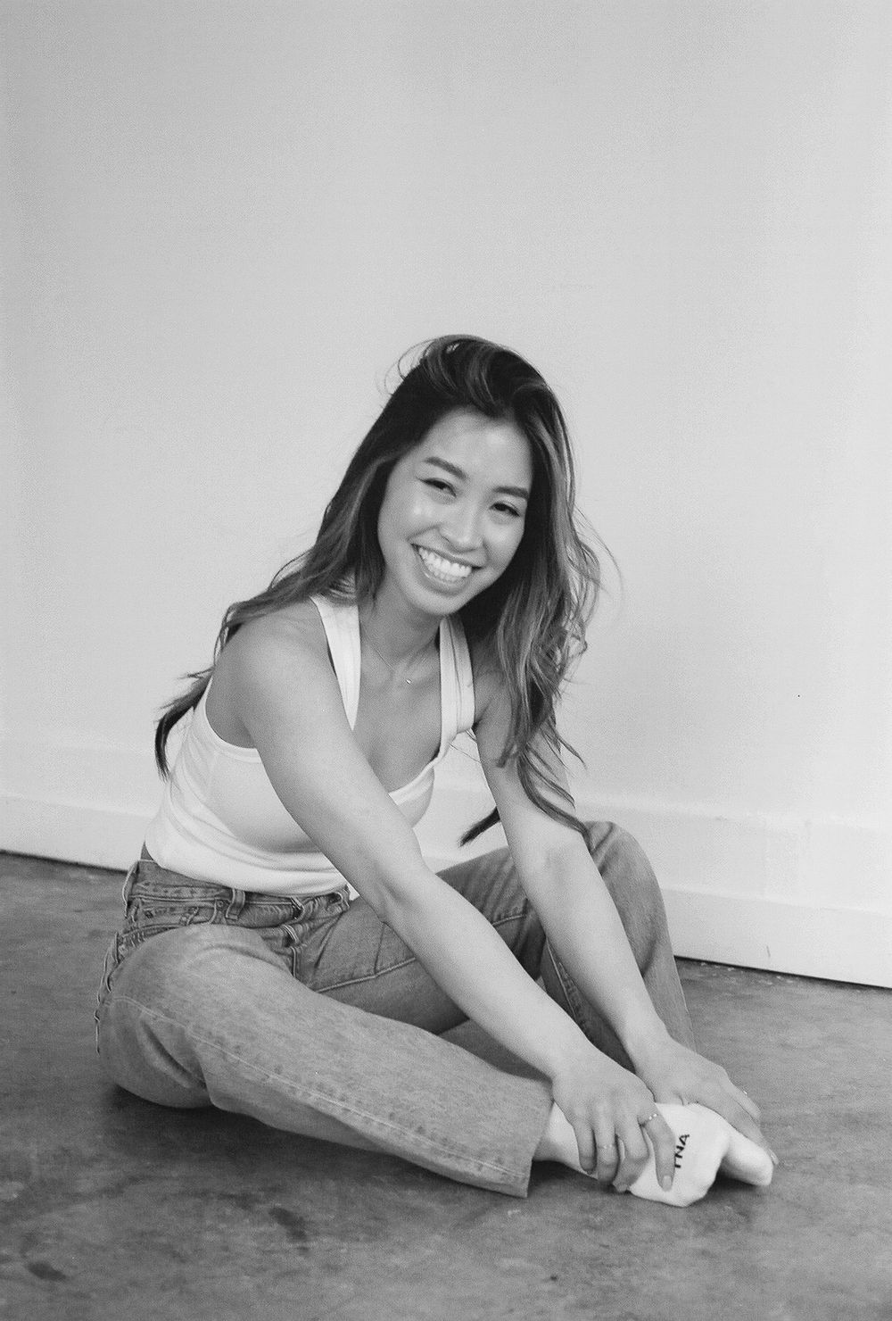 Black and white lifestyle series showing casual poses on wooden floor.
