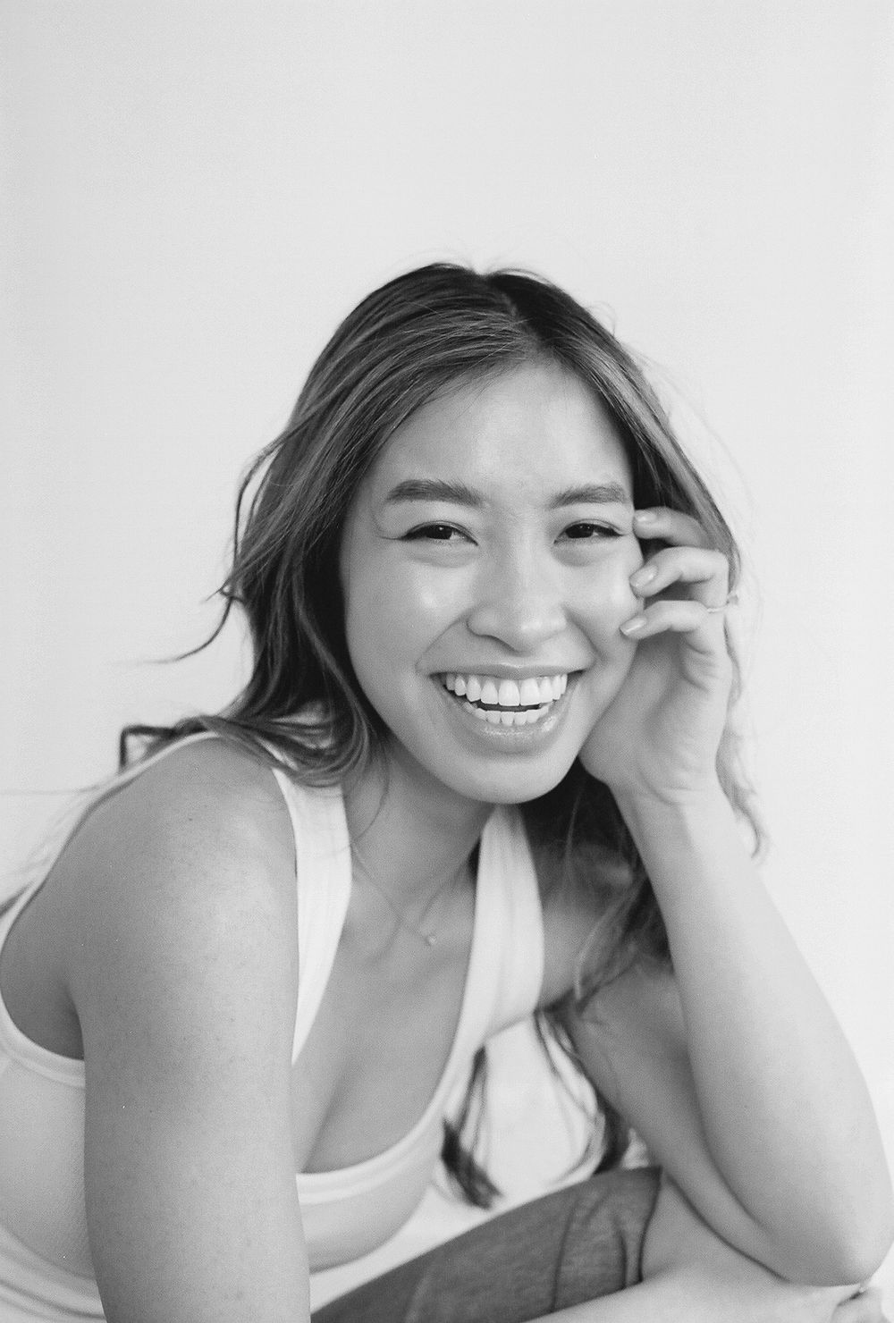 Black and white portrait series showing joyful candid expressions while lying down.