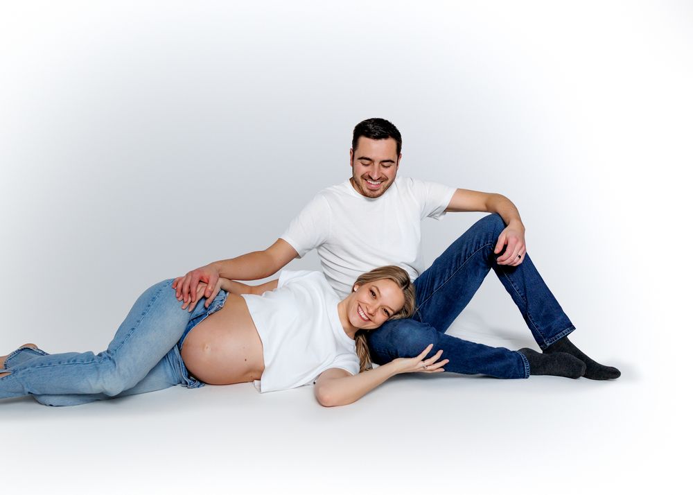 Person wearing blue jeans and socks lying casually on a white background in various relaxed poses.