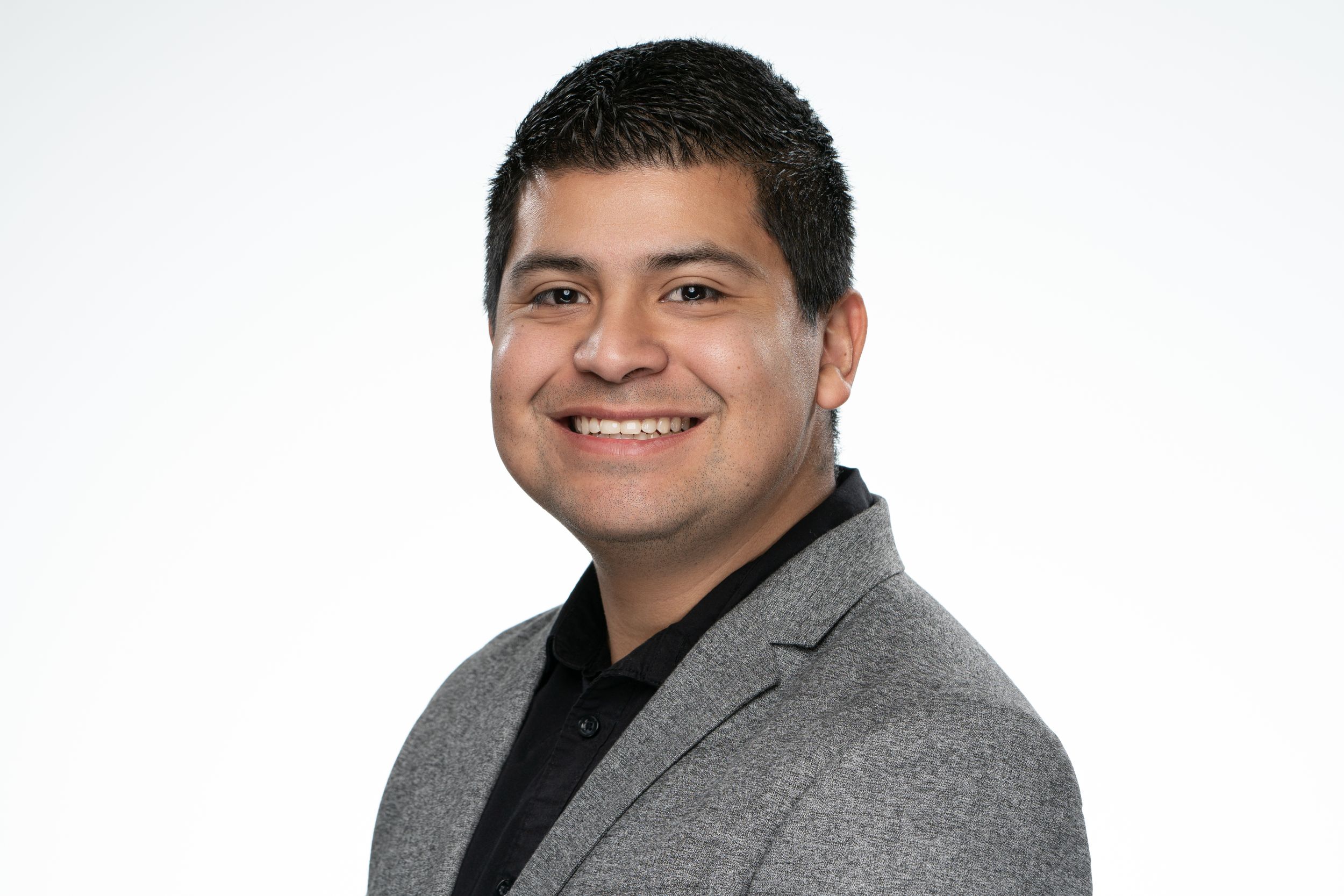 Professional headshot of someone in business attire smiling against a white background.