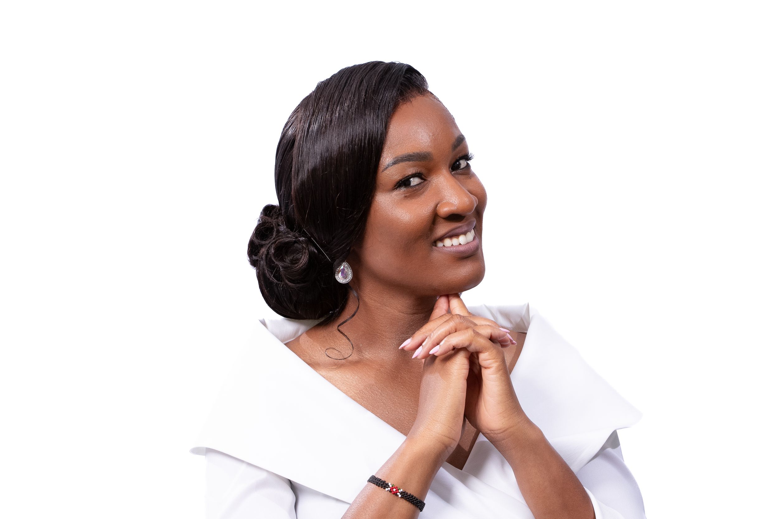 Professional portrait of person in white top with elegant updo hairstyle.