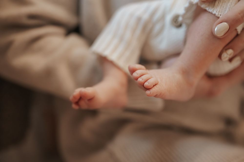 Close-up view of tiny baby feet in soft natural lighting creating a tender newborn moment.