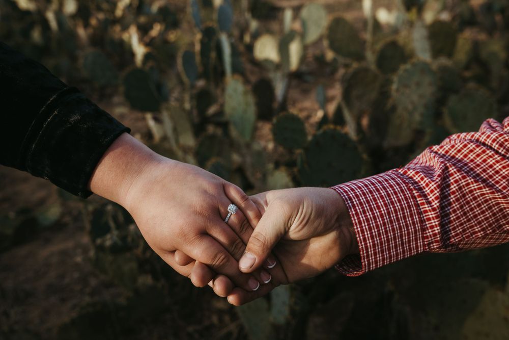 Close-up of two hands joining together against a blurred crowd background.