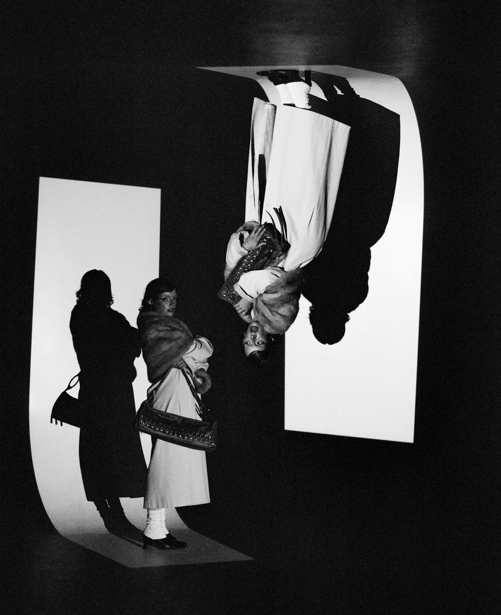 Surreal upside-down fashion photograph with observers in dramatic lighting.