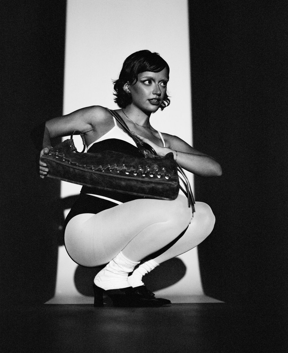 Athletic pose in white leotard against bright background showing dynamic movement.