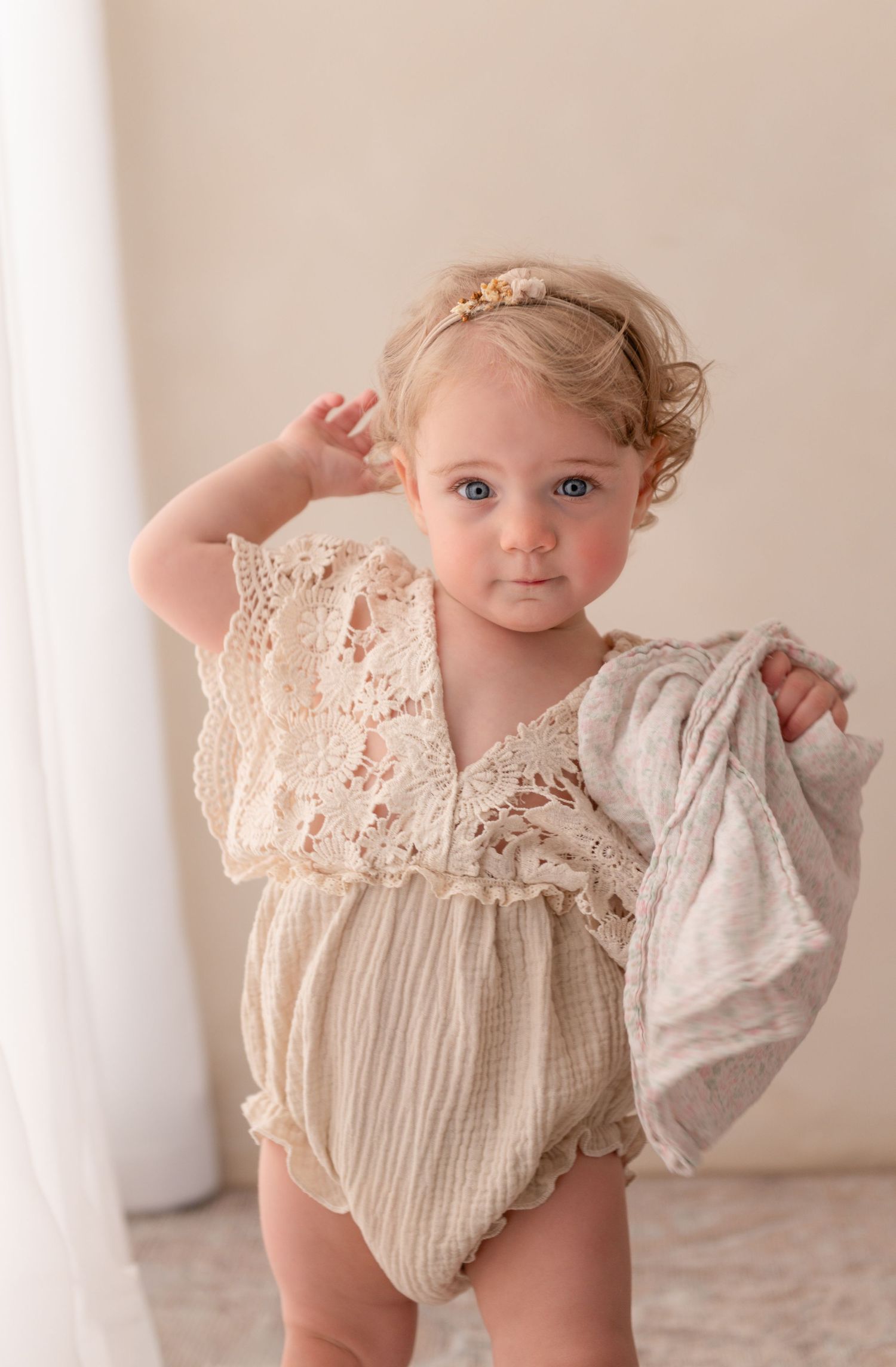 Milestone photography session of baby girl in studio mini client closet neutral pretty clothing.