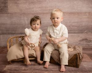 Twins smile candidly at their sitter milestone photography session.