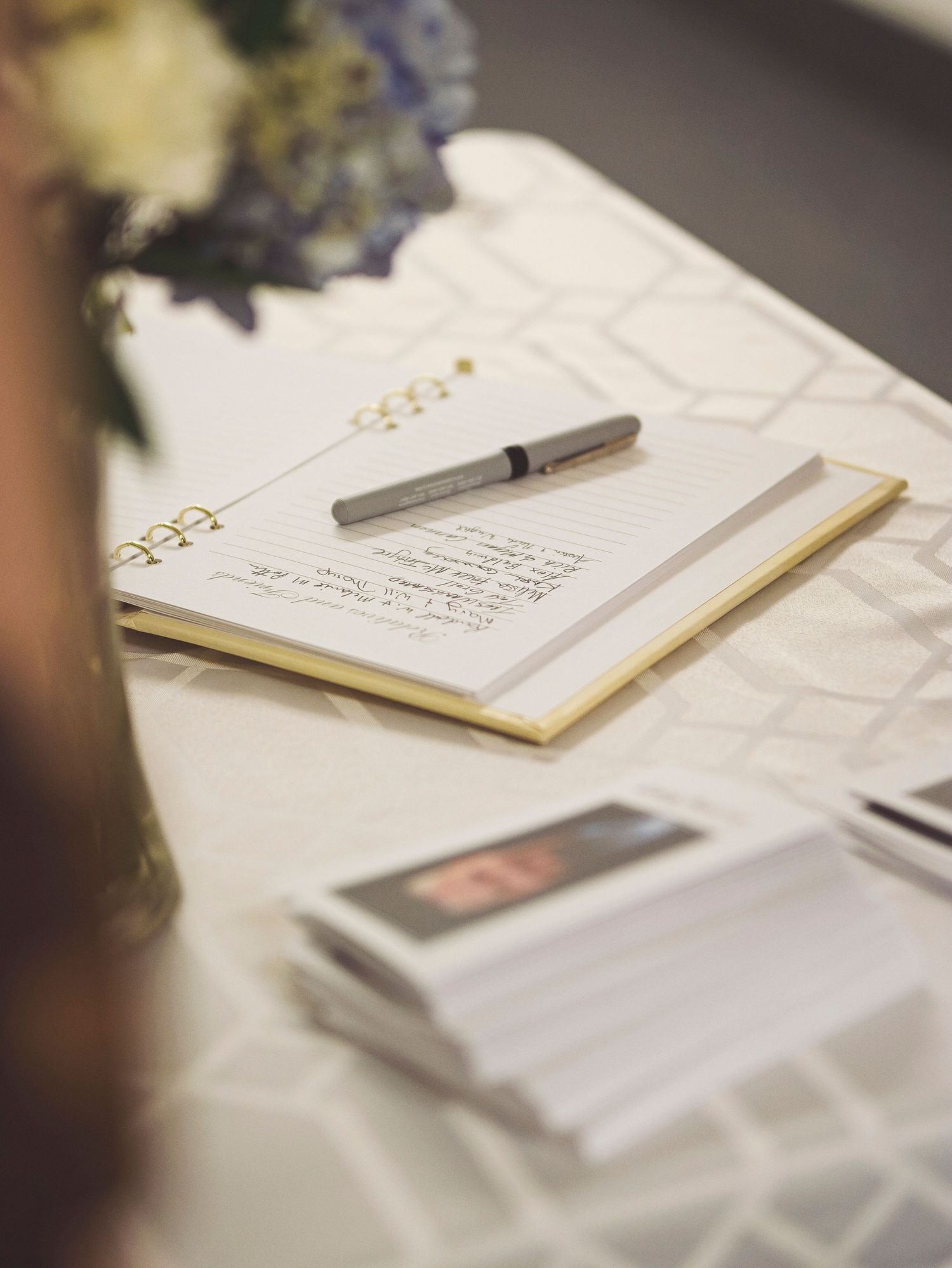 The sign in table at a viewing with the book and vase of flowers and printed program