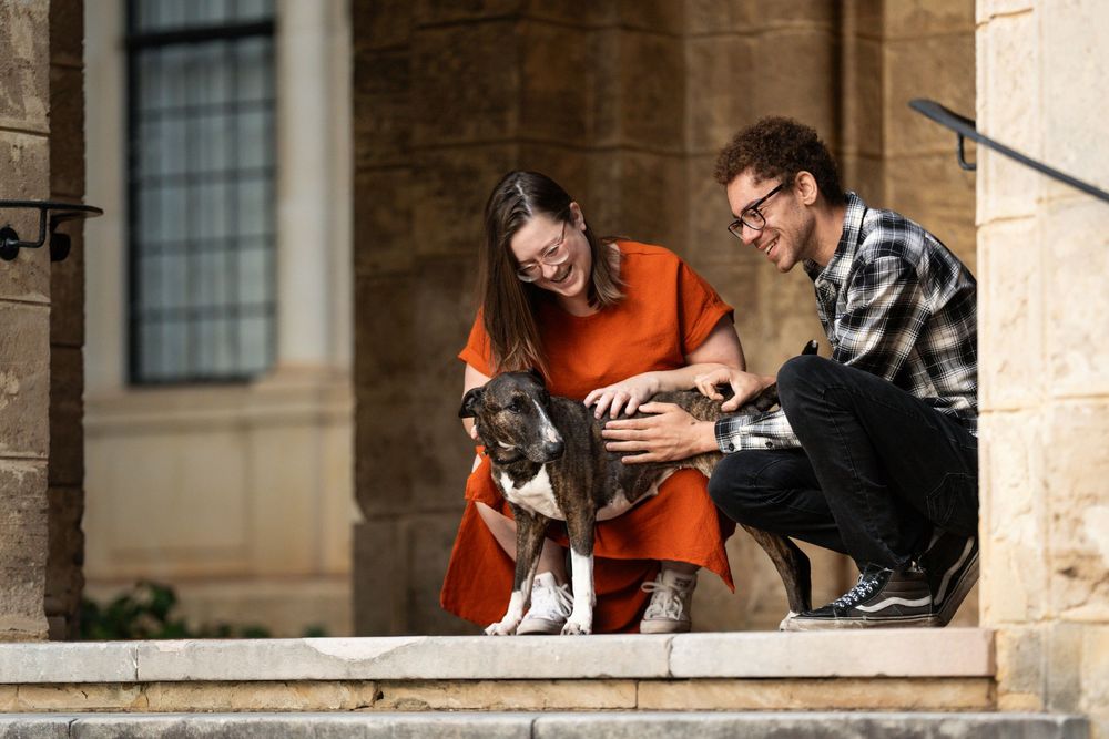 A couple pet their dog during their photoshoot