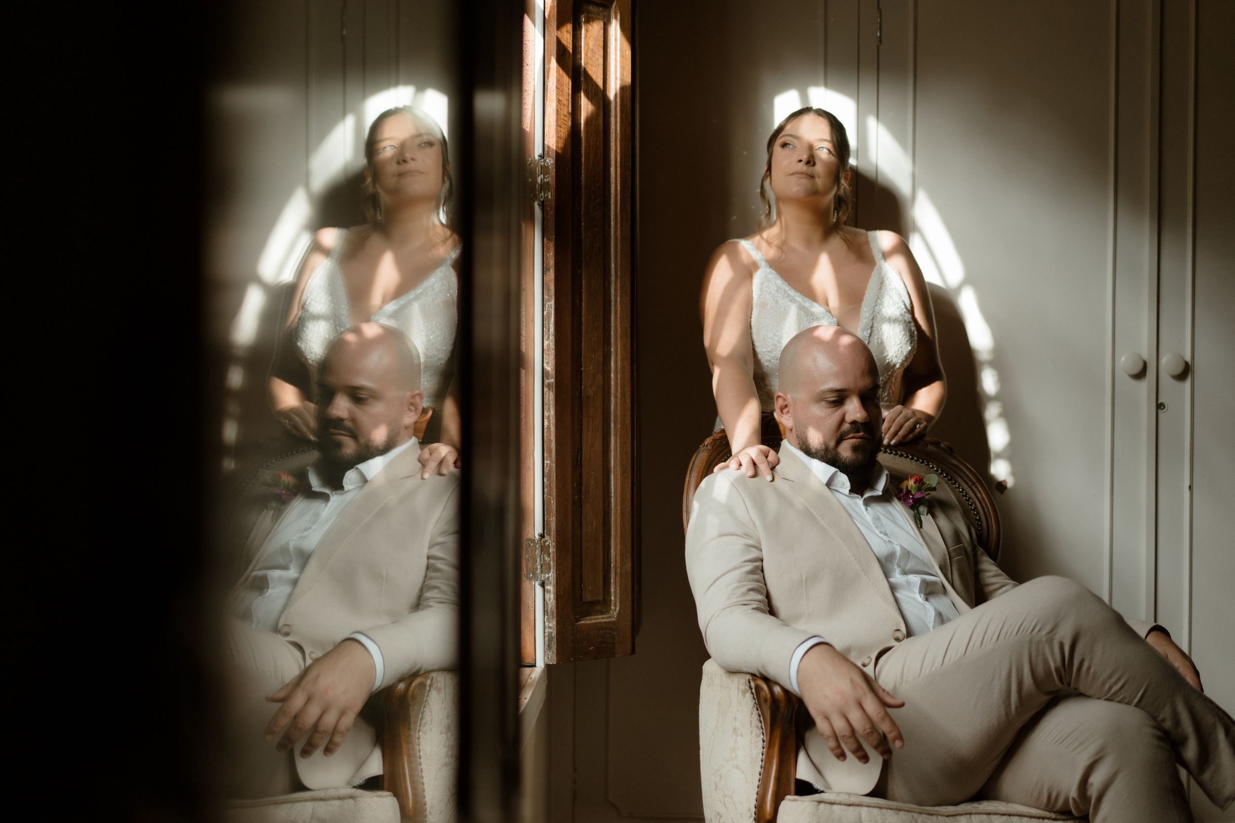 Artistic double reflection wedding portrait showing couple in mirror with ethereal lighting effects.