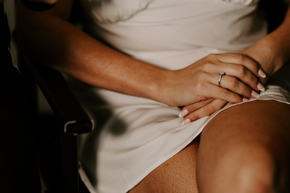 Close-up of hands showing gentle support and care during what appears to be a massage therapy session.