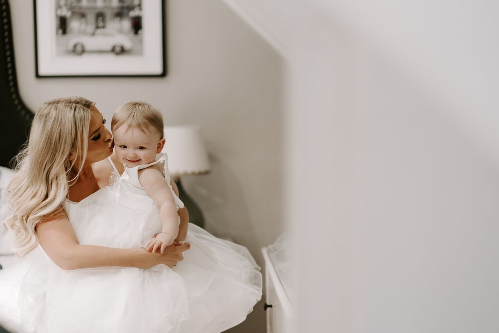 Two figures in a gentle embrace share a tender moment while sitting together on a white background.
