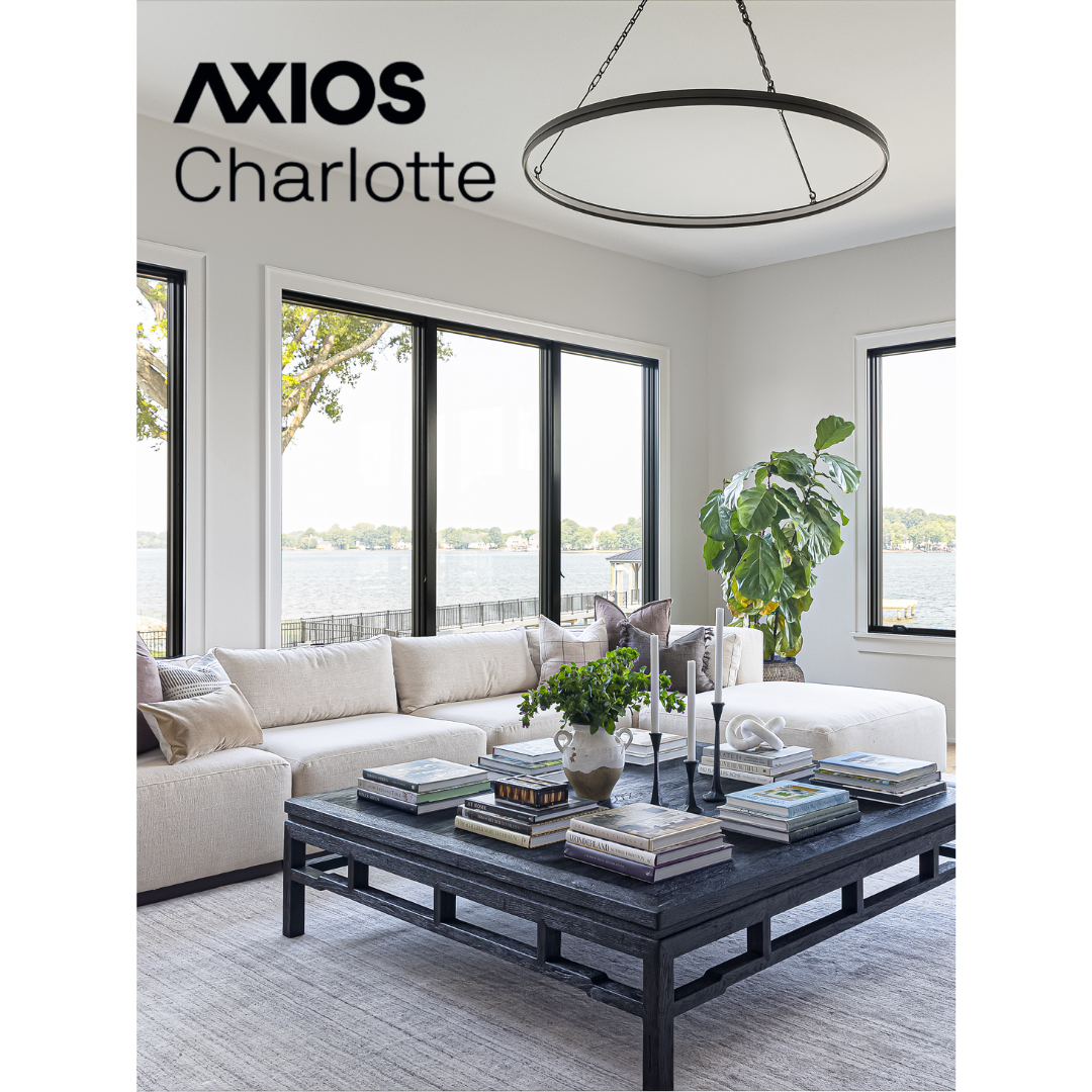 Heather Ison Photography for Axios Charlotte. Modern living room with large circular pendant light, white sectional, and black coffee table.