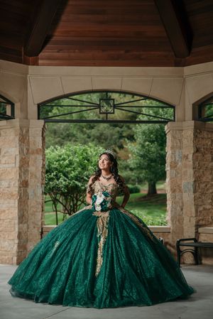 Emerald green formal dress fills frame of rustic pavilion interior.
